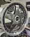 Close-up of a shiny metallic wheel rim on a blurred background