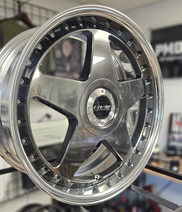 Close-up of a shiny metallic wheel rim in a workshop setting