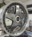 Close-up of a shiny metallic wheel rim in a workshop setting
