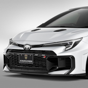 White GR Corolla car with a black grille and front bumper Aimgain carbon fiberbody kit on a gray background pmddriven pmd vip website