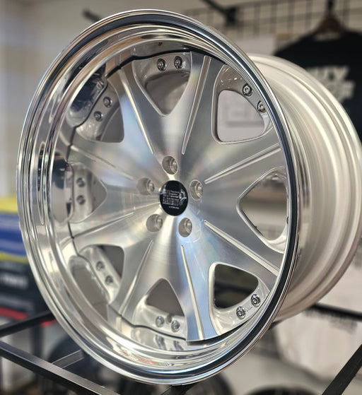 Close-up of a silver car wheel rim with a blurred background