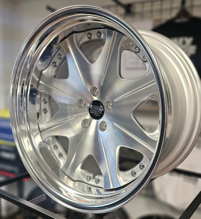 Close-up of a silver car wheel rim with a blurred background