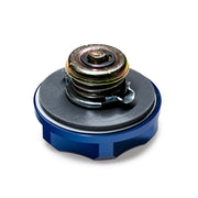 Mechanical component with blue base and metallic top on a white background, featuring 'TOMS' branding.