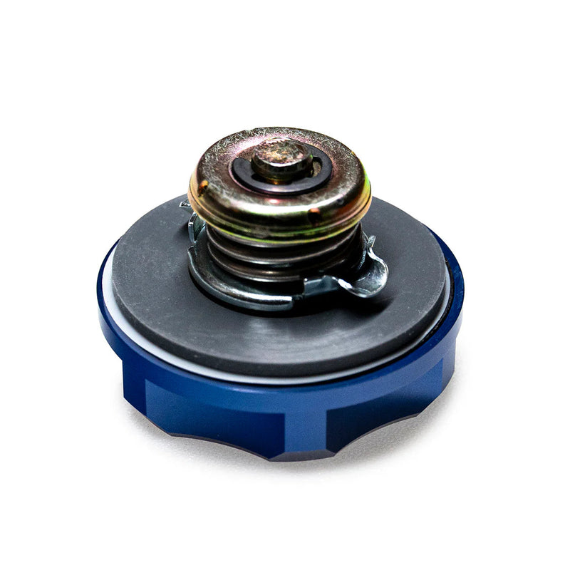 Mechanical component with blue base and metallic top on a white background, featuring 'TOMS' branding.