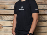 Black MEISTERSCHAFT T-shirt featuring a Lamborghini Aventador design, worn by a person against a wooden backdrop.