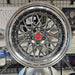 Chrome car wheel rim on display in a showroom setting